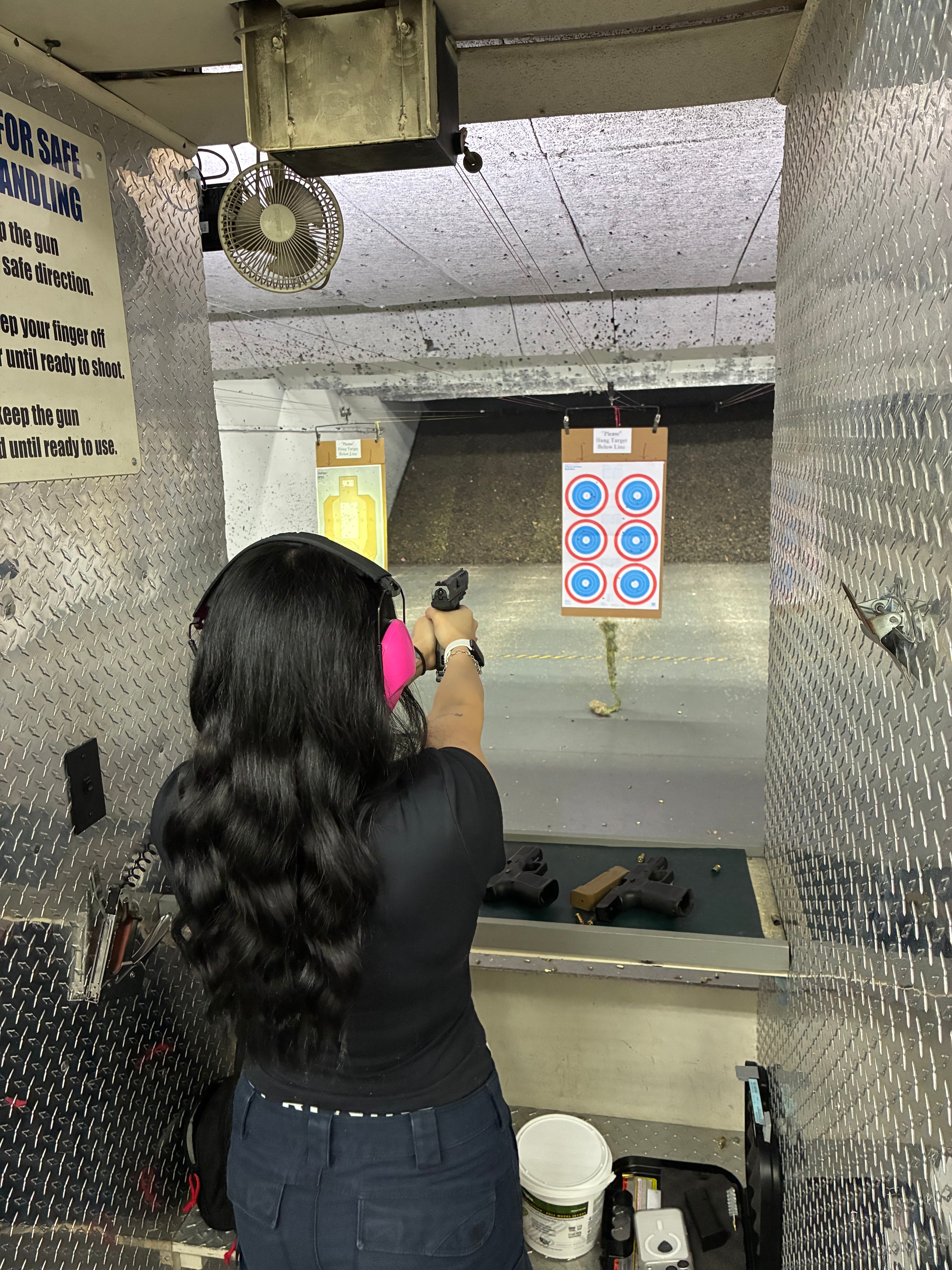 Level III trainee firing at target in indoor shooting range
