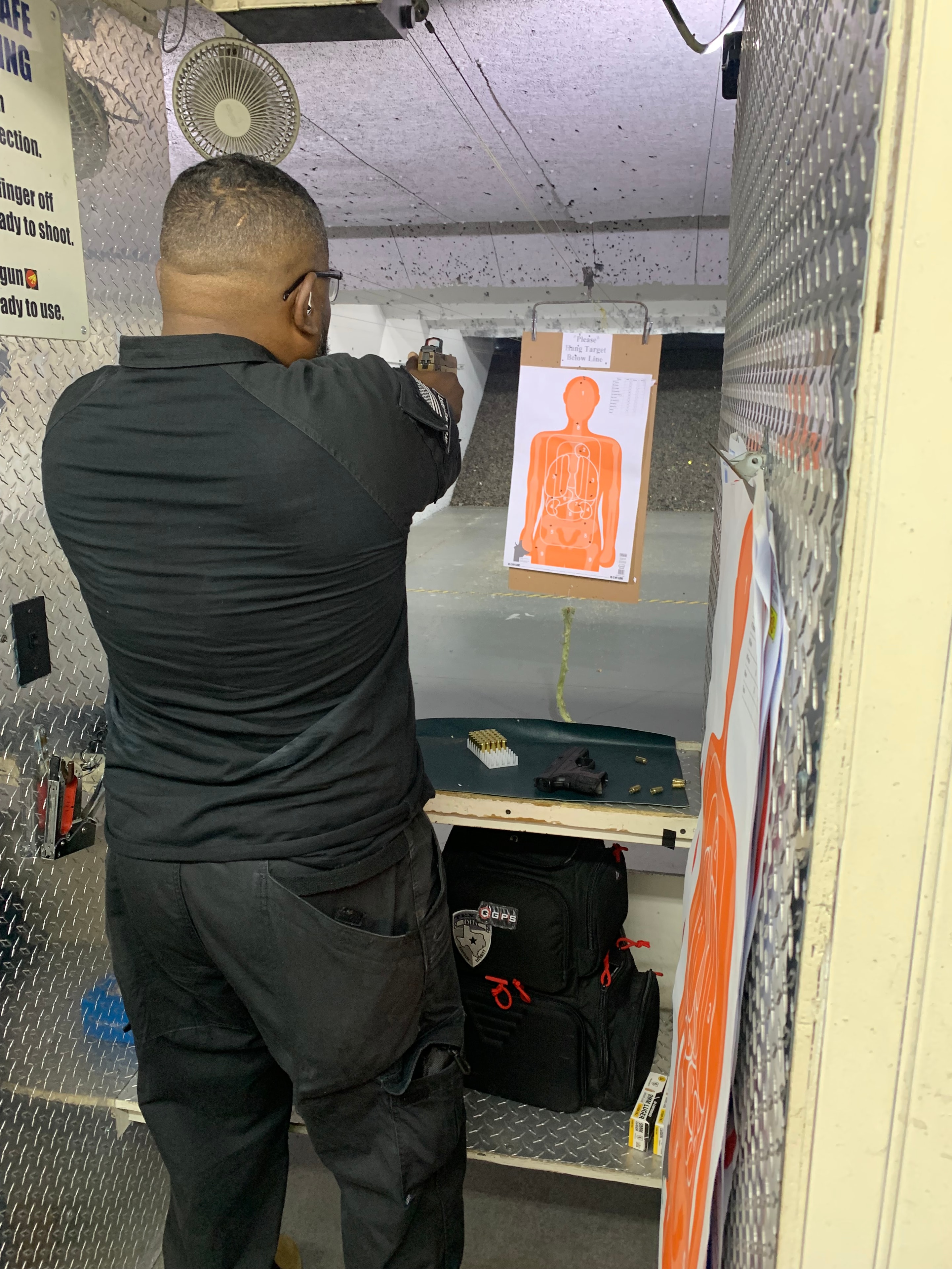 Security officer trainee at indoor range with orange target