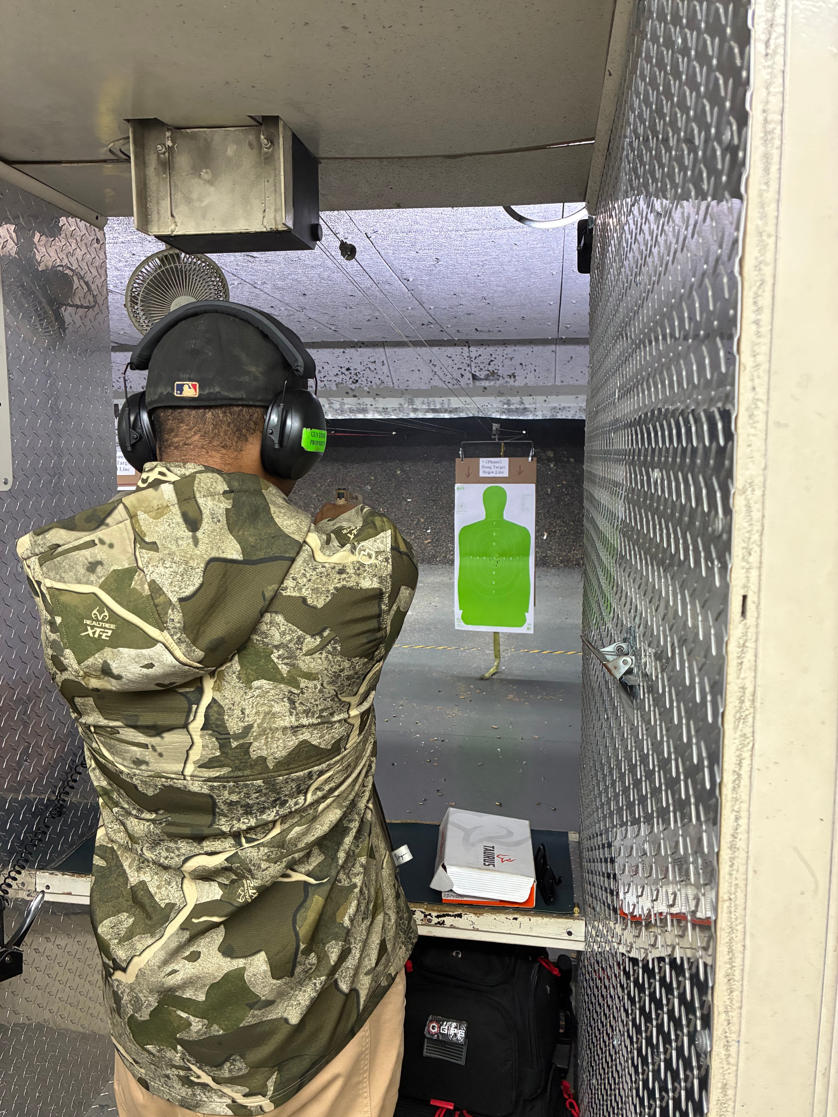 Trainee in camouflage at indoor shooting range
